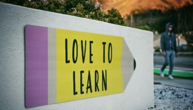 love to learn pencil signage on wall near walking man