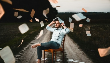 man sitting on chair with book