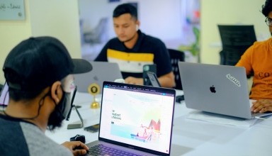 man in gray jacket using macbook pro
