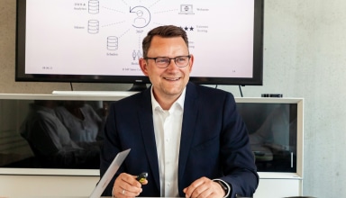 Man in suit smiling in a meeting room