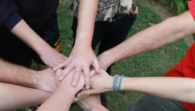 a group of people putting their hands together