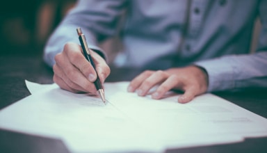 man writing on paper